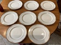 View of all eight dinner plates arranged on a wooden table, showing the design and size.