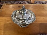 Photo of the covered dish with lid on showing the decorative finial and ornate edge.