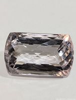 Front view of a large, light purple, faceted amethyst gemstone showing rectangular cushion cut shape and clarity.