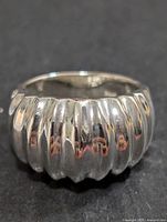 Front view of polished silver ring with ribbed dome design.