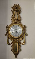 Front view of gold-tone decorative wall-mounted barometer and clock
