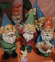 Group of five colorful bobblehead garden gnomes with detailed facial features and clothing.