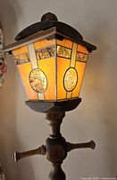 Close-up of stained glass shade and wood finial
