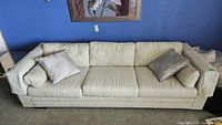 Front view of Elite Shoppe upholstered sofa with cushions showing light beige fabric and decorative pillows.