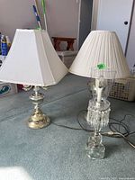 Three table lamps side by side showing metal and glass bases and different lampshade styles
