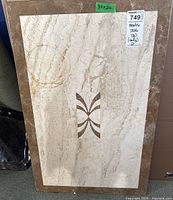 Full view of marble table top 30x20 with decorative central inlay and brown border, showing watermark stain.