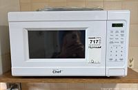 Front view of white Master Chef microwave showing digital control panel and door with window.