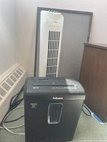 Overview photo showing both the Fellowes paper shredder and the Hawaiian Breeze tower fan together.