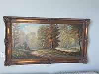 Full frontal image of the framed oil painting showing the entire countryside scene with a winding path and trees in autumn colors.