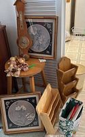 Photo of small wooden stool, framed bamboo style floral prints, wooden barometer, letter holders, and ceramic figurines on stool