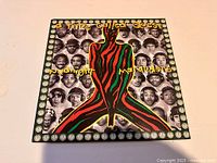 Front cover of the album showing colorful figure and black and white portraits in border