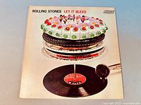 Front cover of the Let It Bleed vinyl LP showing the cake on turntable artwork and London Records label.