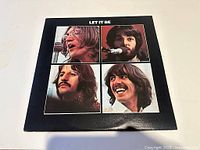 Front cover of 'Let It Be' album showing portraits of the four Beatles members in individual square frames.