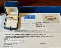 Ring in blue presentation box alongside official appraisal document showing specifications.