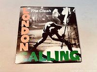 Front cover of The Clash's London Calling vinyl album, showing the iconic image of Joe Strummer smashing his guitar on stage with colorful title text.