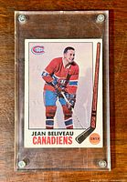 Jean Beliveau hockey card in clear protective case front view showing the player image, team logo, and text.