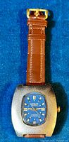 Full view of vintage Rambler wristwatch with blue dial and brown leather strap, showing dial details and watch case.