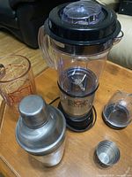 Overview of Magic Bullet blender with blending cup, black base, and chopper accessory, alongside the cocktail shaker.