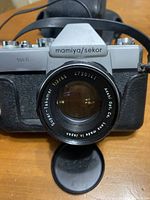 Front view of Mamiya Sekor 500 TL camera with Asahi Super-Takumar 55mm f/2 lens attached and front lens cap removed.