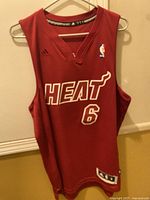 Front view of red Miami Heat basketball jersey with Adidas and NBA logos, showing number 6 and HEAT text.