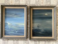 Pair of framed Whalen sea paintings shown side by side on tiled surface, capturing entire lot content.
