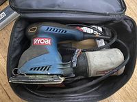 Ryobi electric sander inside zippered carrying case with power cord coiled.