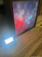 Wood-framed liquid motion lamp and spotlight powered on, displaying red and blue light patterns on glass