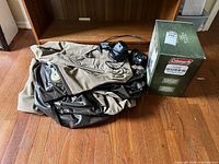 Photo showing unpackaged air mattress, two electric air pumps with power cords, and sealed Coleman Queen airbed box.