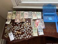 Overview of foreign bills and coins spread on a wooden desk