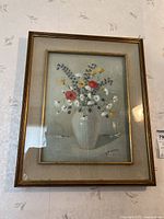 Full view of the framed flower painting under glass, showing the gold-toned frame and linen matting.