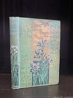 Front cover of the antique book showing green cloth binding with floral and gold designs.
