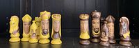 Front view of yellow and brown hand-painted wooden chess pieces with medieval designs, no board included.
