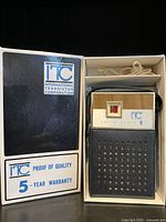 Front view of the ITC transistor radio in its original box, showing the radio and original earpiece above it.