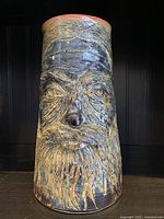 Front view of large Brutalist vase with detailed carved face and textured beard and hair.