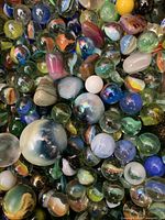 Close-up photo showing a variety of vintage glass marbles with different colors and patterns.