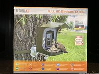 Product box front showing the birdcam mounted on a tree with a bird feeding