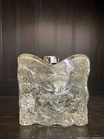 Front view of clear glass textured cube table lighter with embedded panther figure and metal ignition on top.