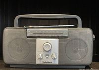 Front view of vintage mini Radio Shack AM/FM portable radio ghetto blaster with speaker grill, dials, and carry handle visible.