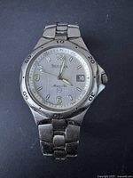 Front view of the Bulova Marine Star watch showing the silver dial, luminous hour markers, minute markers on the bezel, and date window.