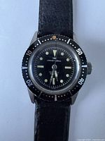 Front view on leather strap showing bezel, dial and hands