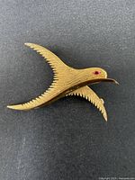 Gold-tone detailed bird brooch viewed from above