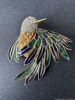 Close-up photo of the eagle brooch showing detailed enamel wings and rhinestone head.