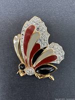 Front view of the butterfly-shaped brooch showing rhinestones and enamel detailing.
