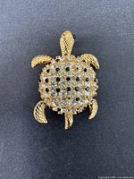 Full front view of the vintage turtle brooch showing gold-tone metal and rhinestone decoration
