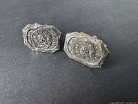 Pair of vintage sterling silver cufflinks featuring Aztec calendar design with geometric border pattern and Mexican silver hallmark.