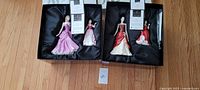 Four Royal Doulton Pretty Ladies porcelain figurines in original boxes set on wooden floor.