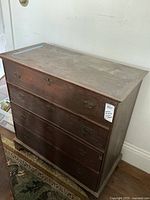 Front view of the antique solid pine chest of drawers showing four drawers with metal handles and aged wood finish.
