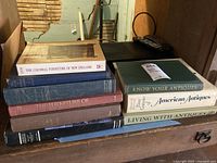 Photo of a stack of six hardcover books related to American antiques and colonial furniture, showing titles on spines and covers.