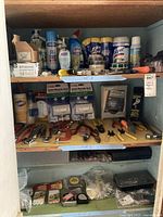 Overview of shelving unit with various cleaning supplies such as Clorox bleach, Lysol wipes, antibacterial Softsoap hand soap, carbon monoxide alarms, pliers, wrenches, and measuring tapes.