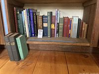 Shelf of hardcover books on various topics such as art, gardening, American theatre, poetry and history.